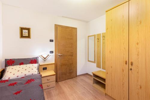 a bedroom with a bed and a wooden cabinet at Villa Maria Moena in Moena