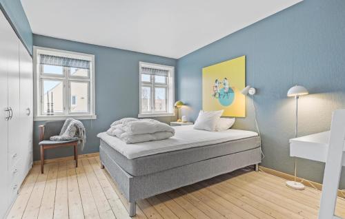 Løgstør的住宿－4 Bedroom Cozy Home In Lgstr，一间卧室设有一张床和蓝色的墙壁