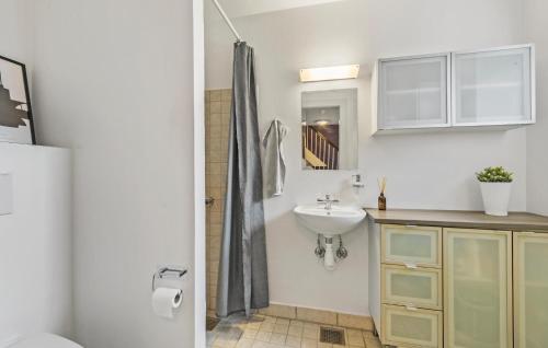a white bathroom with a sink and a mirror at 4 Bedroom Cozy Home In Løgstør in Løgstør