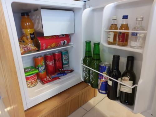 an open refrigerator filled with drinks and soda at Hotel Black Sea in Batumi