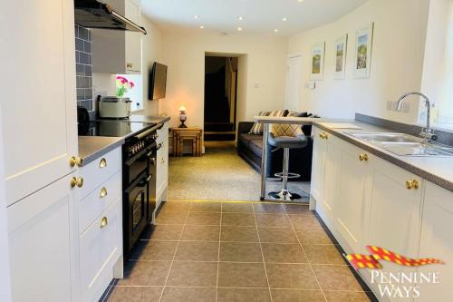eine Küche mit einer Spüle und einer Arbeitsplatte in der Unterkunft The West Wing, Featherstone in Coanwood