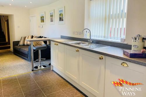 a kitchen with a sink and a counter top at The West Wing, Featherstone in Coanwood