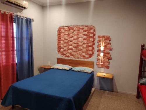 a bedroom with a blue bed and a brick wall at Cabañas Alicia in San Rafael