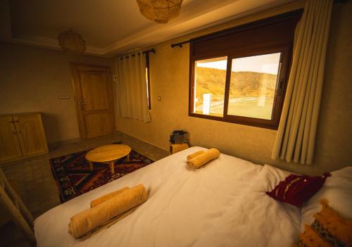 a bedroom with a bed with two pillows on it at The Moroccan Surf House in Imsouane