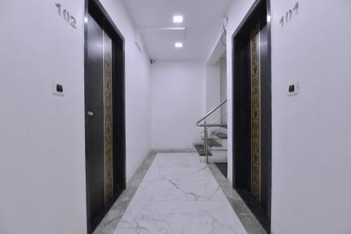 a hallway with two black doors and a marble floor at OYO Neha's Kitchen in Ābu Road