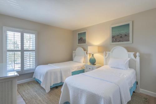 two beds in a room with two windows at SOUTH SEAS BEACH VILLA 2428 in Captiva