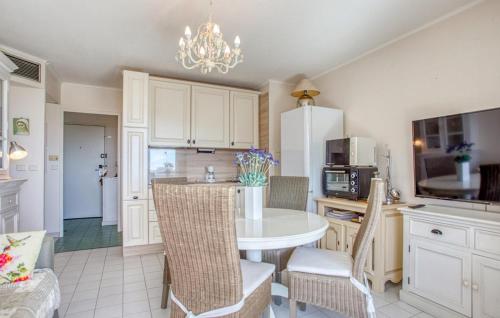 Il comprend une cuisine avec une table et des chaises blanches ainsi qu'une cuisine équipée d'un réfrigérateur. dans l'établissement Cozy Apartment In Mandelieu-La-Napoule, à Mandelieu-la-Napoule