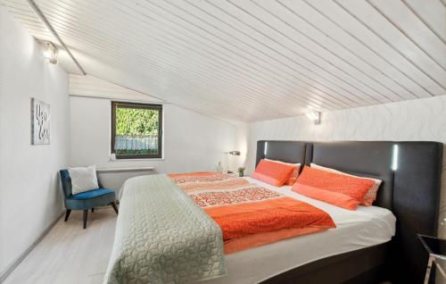 ein Schlafzimmer mit einem großen Bett mit orangefarbenen Kissen in der Unterkunft Ferienhaus Auf Dem Sand 