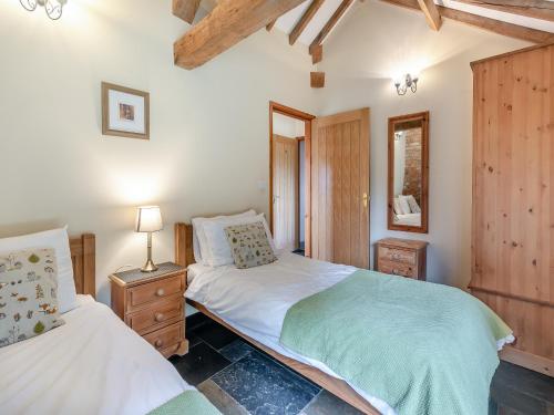 a bedroom with two twin beds and a mirror at Ings Barn in Thorpe Saint Peter