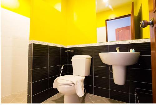a bathroom with a toilet and a sink at Takanta Place in Udon Thani