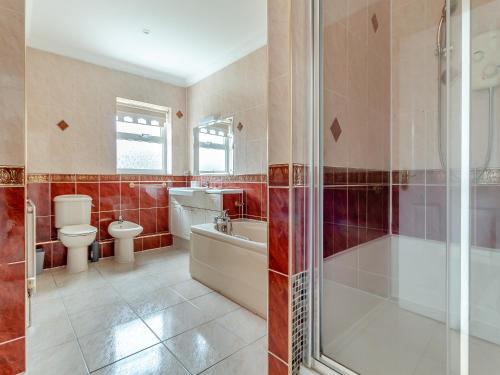 uma casa de banho com uma banheira, um WC e um chuveiro em The Great Escape em Ipswich