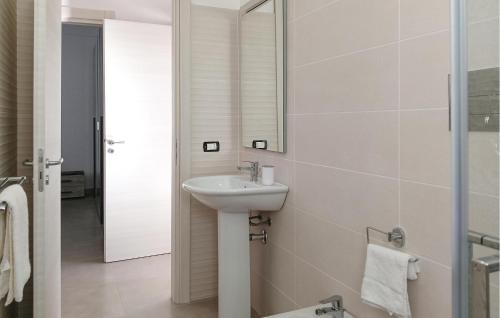 een witte badkamer met een wastafel en een spiegel bij Pet Friendly Home In Realmonte With Kitchen in Realmonte