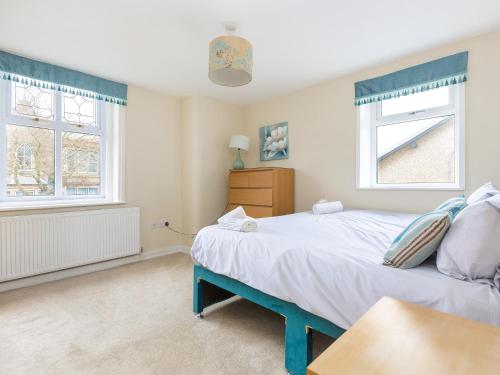 a bedroom with a large bed and two windows at Mulberry House in Lytham St Annes