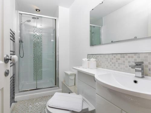 a bathroom with a shower and a toilet and a sink at Mulberry House in Lytham St Annes
