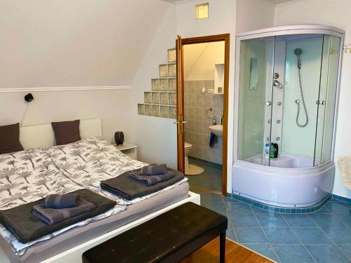 a bedroom with a shower and a bed and a tub at Apartment in Gyenesdias - Balaton 18867 in Gyenesdiás