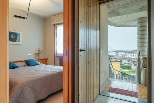 Schlafzimmer mit einem Bett und Blick auf einen Balkon in der Unterkunft Interno 18 in Clusane sul Lago