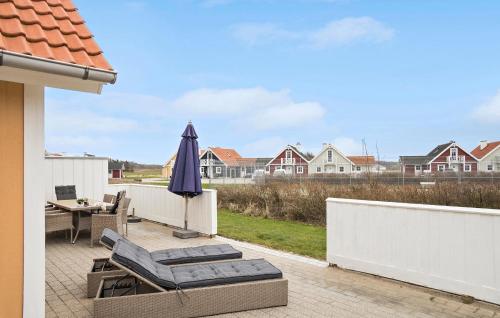 a patio with an umbrella and chairs and a table at Holiday Home Strandgårdsvej V in Bro