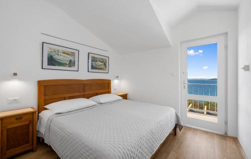 a white bedroom with a bed and a window at Stunning Home In Murter With House Sea View in Murter