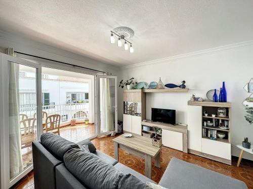 un soggiorno con un divano e un tavolo di Apartamento acogedor cerca del mar en Fornells a Fornells