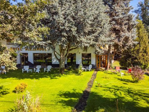 una casa con un patio con sillas y un árbol en Alejandro en Junín de los Andes