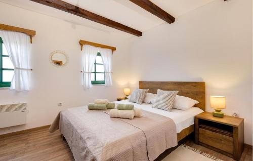 a white bedroom with a large bed and two windows at Amazing Home In Podgorje Bistricko With Kitchen in Marija Bistrica