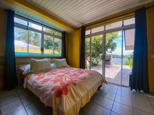 a bedroom with a bed in a room with windows at Villa Mitirapa in Tohautu