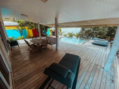 a wooden deck with a table and chairs and a pool at Villa Mitirapa in Tohautu