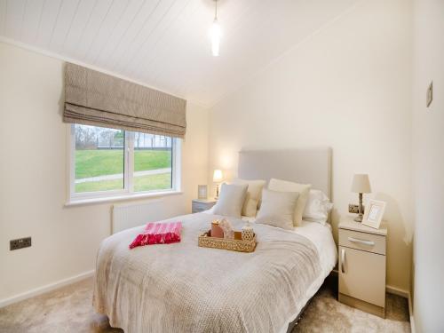 um quarto com uma grande cama branca e uma janela em Oak View Lodge em Llanrhaiadr