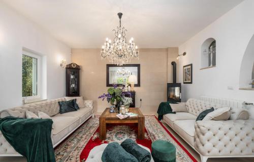 a living room with white couches and a chandelier at Villa Duga in Poreč