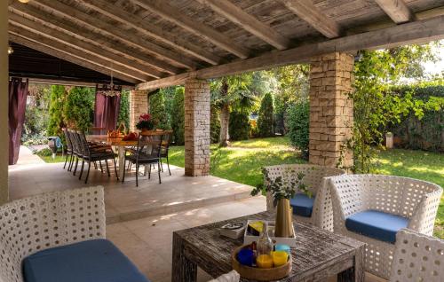 an outdoor patio with chairs and a table with a table at Villa Duga in Poreč