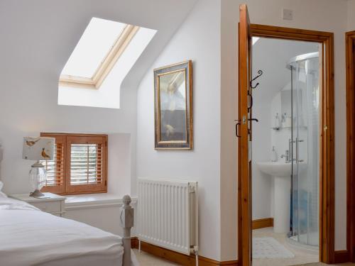 a bedroom with a bed and a shower and a sink at Mill Barn in Milfield