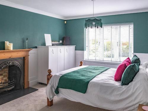 1 dormitorio con 1 cama y chimenea en Cranny Hill en Walpole