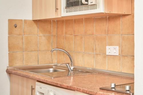 une cuisine avec un évier et un micro-ondes dans l'établissement Apartamento Almijara 2, à Nerja