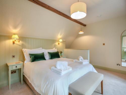 a bedroom with a large white bed with green pillows at Keeds Barn in Arundel