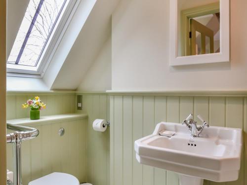 ein Bad mit einem Waschbecken und einem Fenster in der Unterkunft Keeds Barn in Arundel