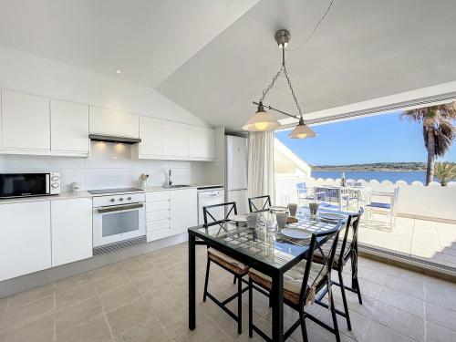 a kitchen and dining room with a table with chairs at Roca Fornells, Atico Maritimo F05 in Fornells