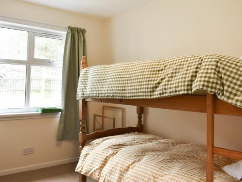 a bunk bed in a room with a window at Mains Of Asloun Two - Uk44788 in Alford