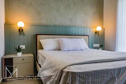 una camera da letto con un grande letto con cuscini bianchi di Canterbury Golf Resort Apartments a Piliyandala