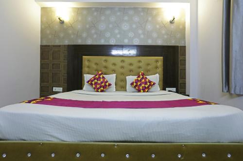 a bedroom with a large bed with two pillows at Airport KINGDOM in New Delhi