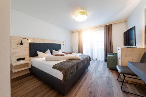 a hotel room with a bed and a flat screen tv at Landrefugium Obermüller 4,5 Sterne in Untergriesbach