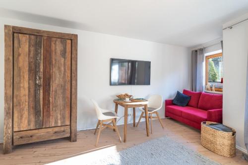 uma sala de estar com um sofá vermelho e uma mesa em Tobel em Bad Hindelang