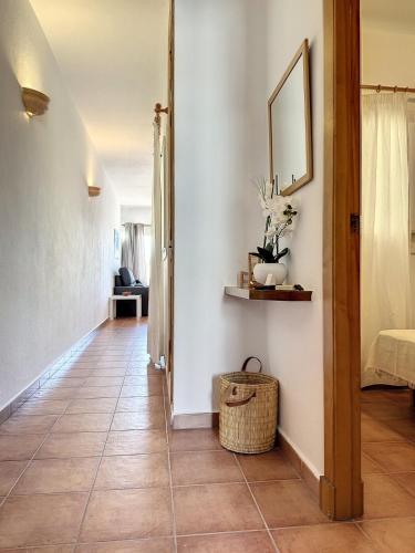 a hallway with a tile floor and a mirror at F105 · Dos dormitorios, terraza y a/c en Fornells in Fornells