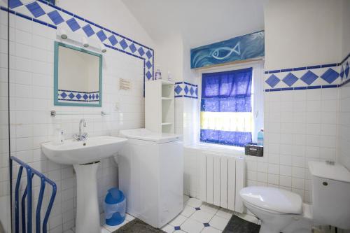 baño con lavabo y aseo y ventana en Longere ancienne - Ty 2, en Erdeven