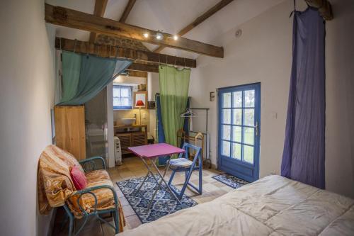 1 dormitorio con 1 cama, mesa y sillas en Longere ancienne - Ty 2, en Erdeven