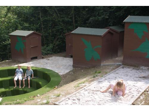 two children playing in a playground with play huts at Mountain Retreat for Group in Daverdisse