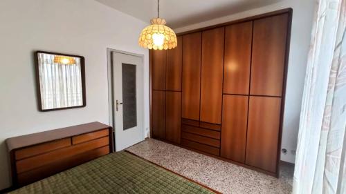 um quarto com uma cama, um armário e um lustre em Casa Riverbero em Novara