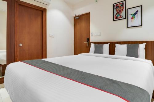 a bedroom with a large white bed in a room at Super Townhouse 1144 Hotel RCC 7 Lamps in Alipur