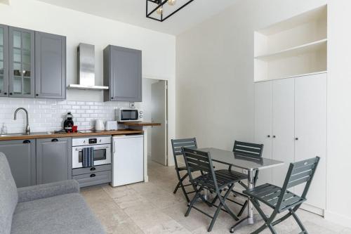 a kitchen with a table and chairs in a room at Chemin Vert/Voltaire : Charming Apartment 4P in Paris