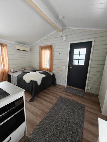 a bedroom with a bed and a window and a door at Aava Sky Village Aurinkomaja in Aavasaksa