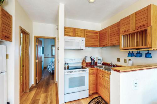 a kitchen with wooden cabinets and a white stove top oven at Timber Ridge 504B in Silverthorne